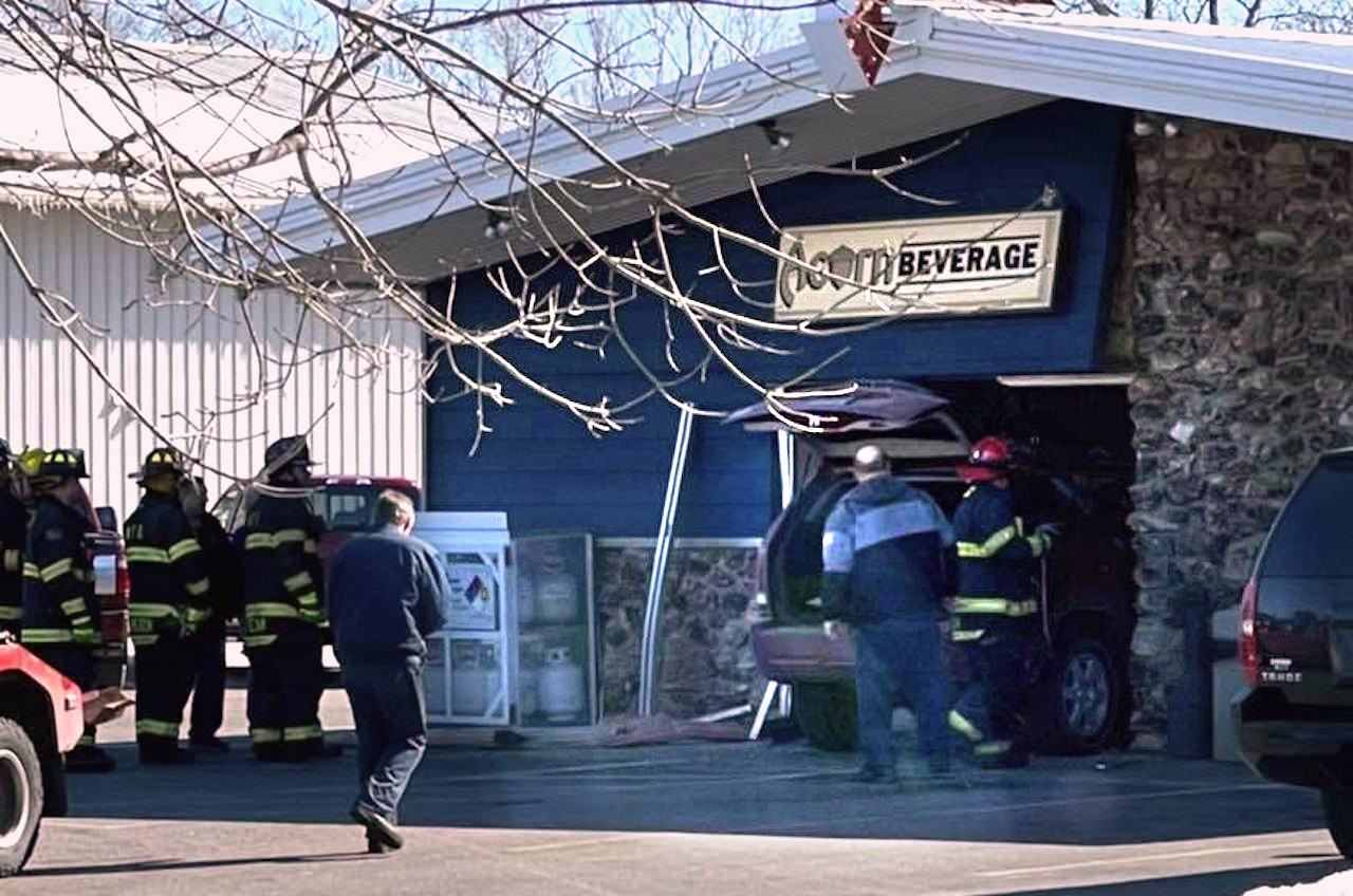 Emergency crews work to remove a car from a business Monday in Whitewater.