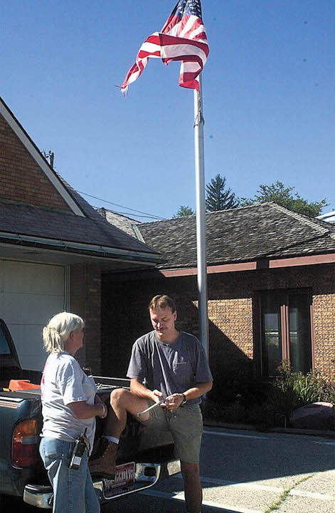 Rescue Chief Rob Way, right, and Teddy Menasco, asst. rescue chief, stand outside the Williams Bay fire station below the flag the morning of Sept. 11, 2001. The flag had been lowered to half staff following the terrorist attacks of 9/11. Dan Plutchak photo.