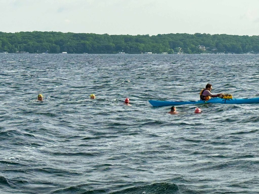 Kayaker Jacob Austin with the five elite swimmers from Louisville, Chicago and Madison who completed the length of Geneva Lake in 4 hours, 15 minutes.